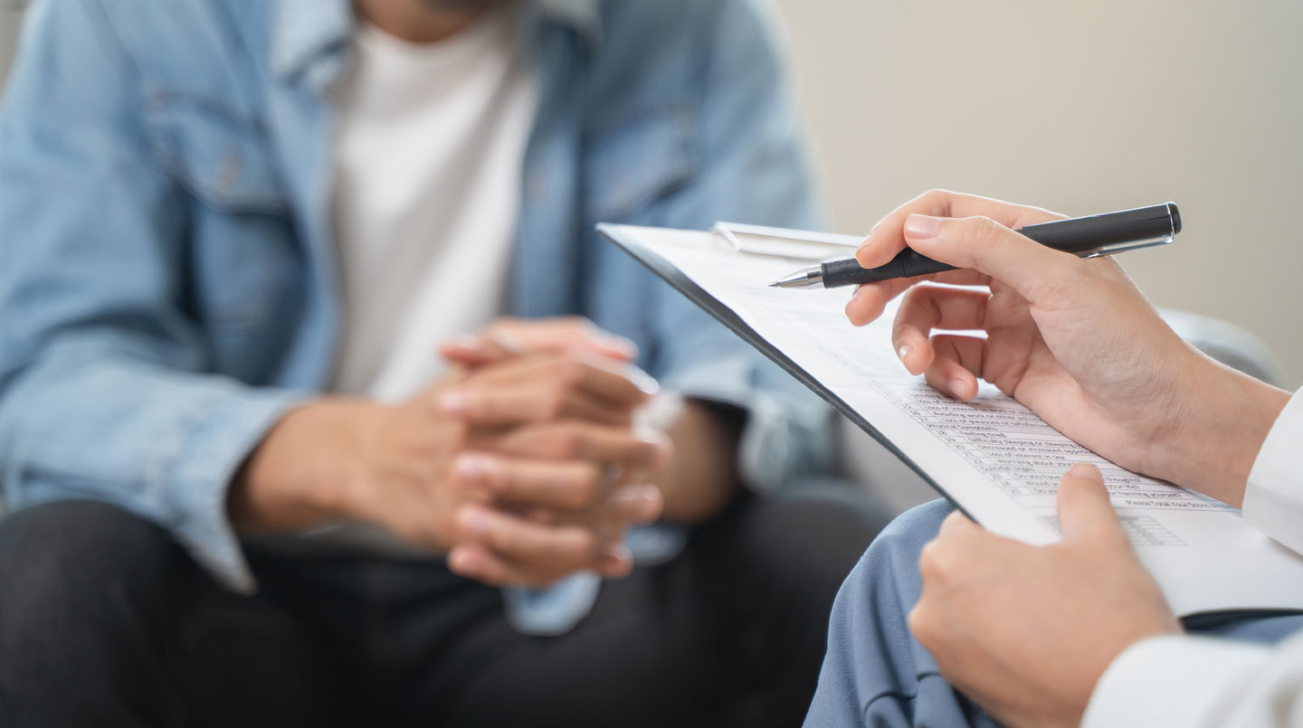 Deux personnes vues de dos consultent ensemble des documents médicaux anciens dans un environnement lumineux et contemporain, concentrées sur leur lecture
